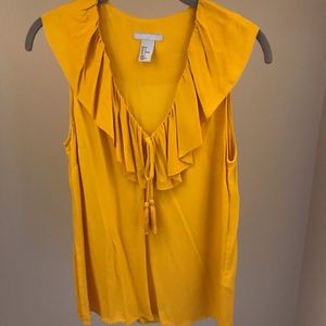 Mustard yellow frilly sleeveless top.